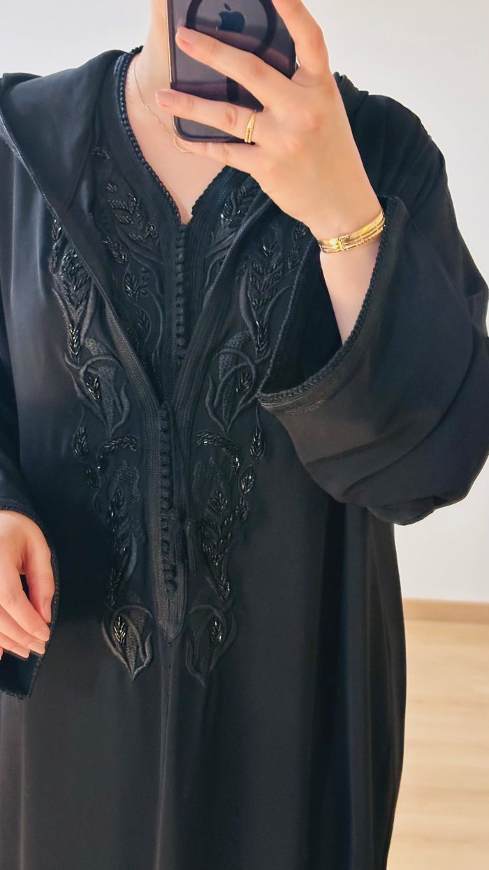 femme qui porte une djellaba kmiss RAZANE en noir de la marque sAPHIR CAFTAN