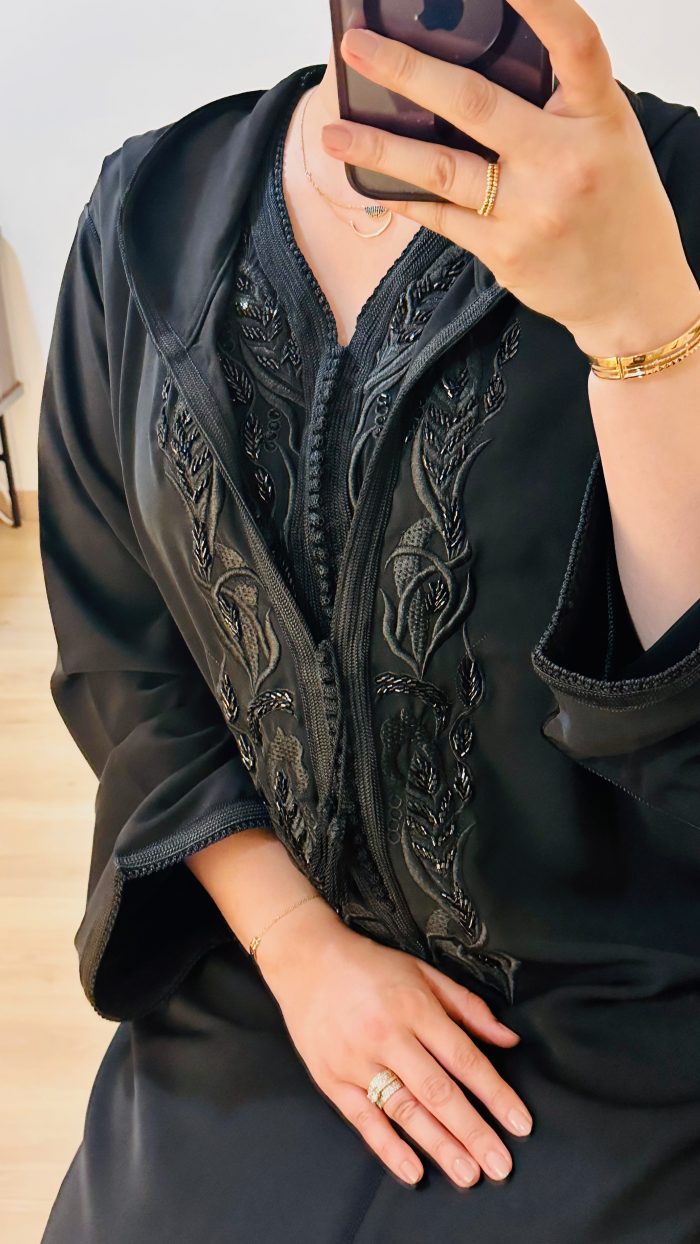 femme qui porte une djellaba kmiss RAZANE en noir de la marque sAPHIR CAFTAN