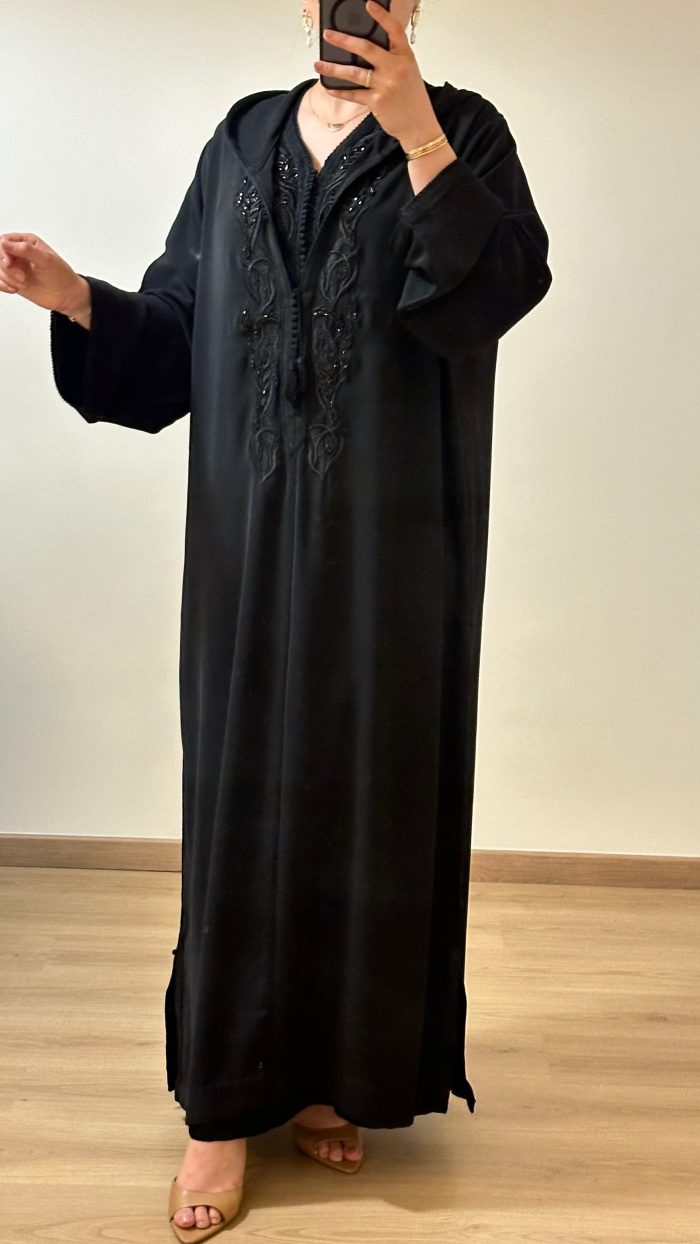 femme qui porte une djellaba kmiss RAZANE en noir de la marque sAPHIR CAFTAN