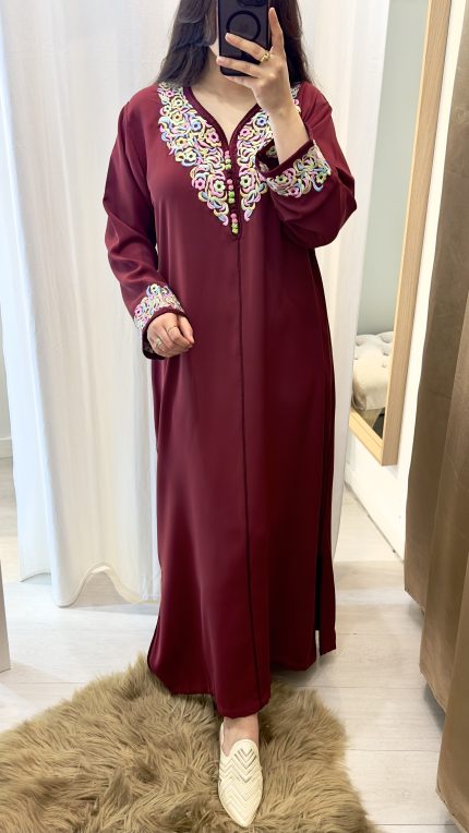 femme qui porte un kmiss/robe traditionnelle marocaine avec ds broderies en une seule pièce couleur bordeaux