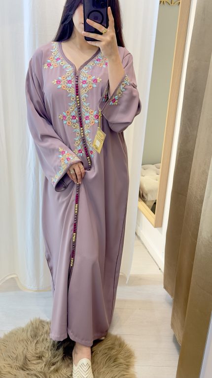 femme qui porte un kmiss/robe traditionnelle marocaine avec ds broderies en une seule pièce couleur mauve