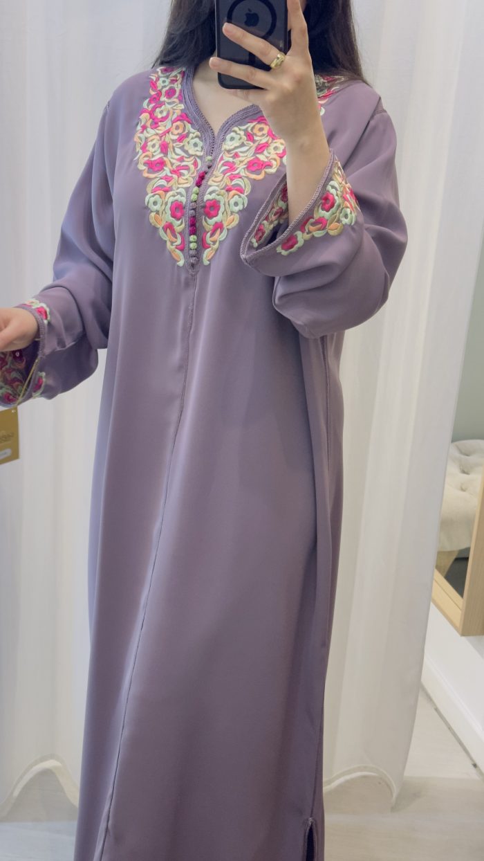 femme qui porte un kmiss/robe traditionnelle marocaine avec ds broderies en une seule pièce couleur mauve