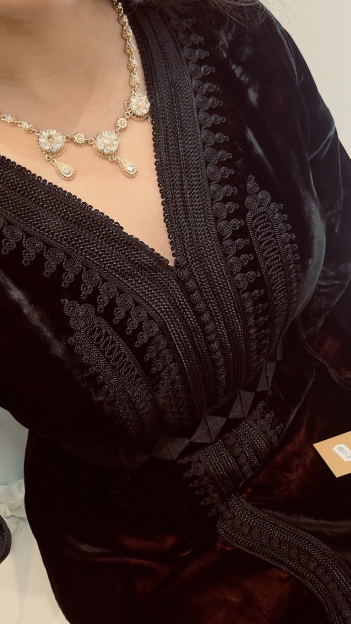 une femme porte un caftan noir en velours avec ceinture