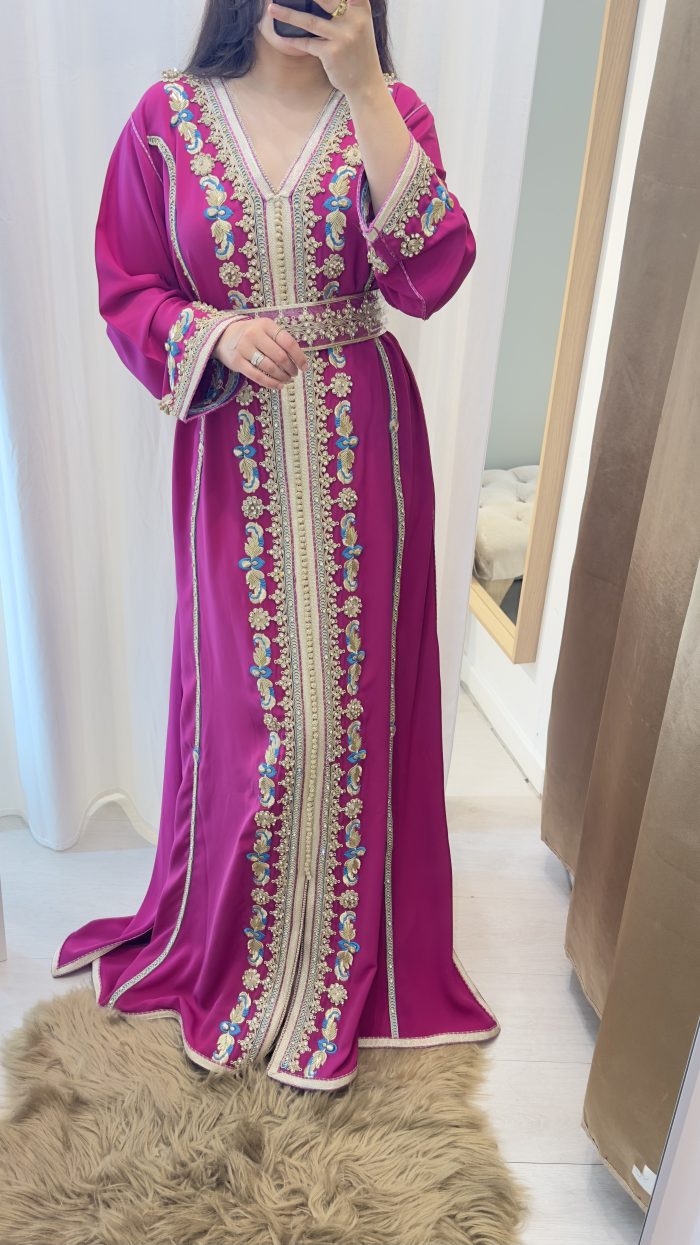 FEMME QUI PORTE UN CAFTAN marocain BRODé ET PERLé de couleur fuchsia avec ceinture