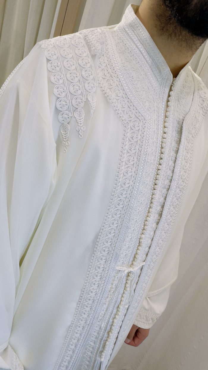 homme qui porte un jabador, un ensemble en trois pièces traditionnel marocain en couleur blanche